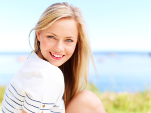 Blonde girl smiling with water in the background