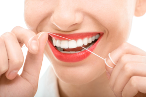 Woman flossing teeth smiling, happy with perfect teeth and toothy smile on white background