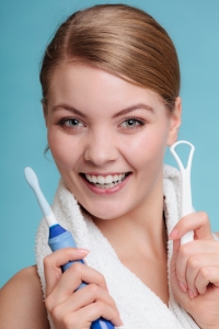 Woman with toothbrush and tongue scraper